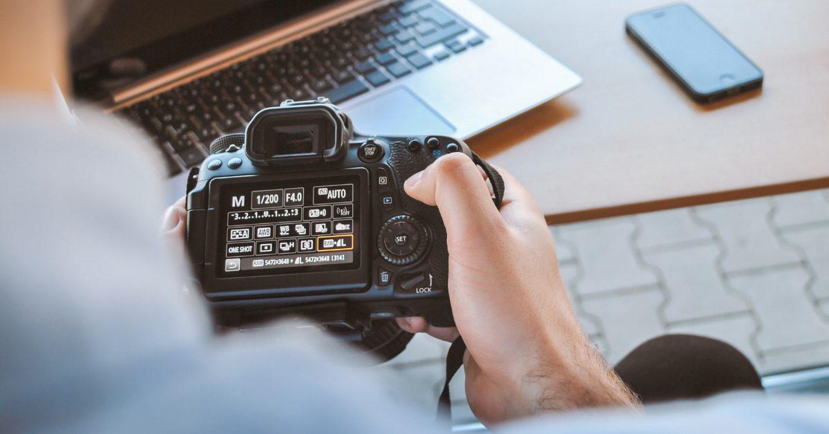 Repurposing Content for Maximum Impact and Value 1 Repurposing content : man holding a camera looking and adjusting the menu settings.
