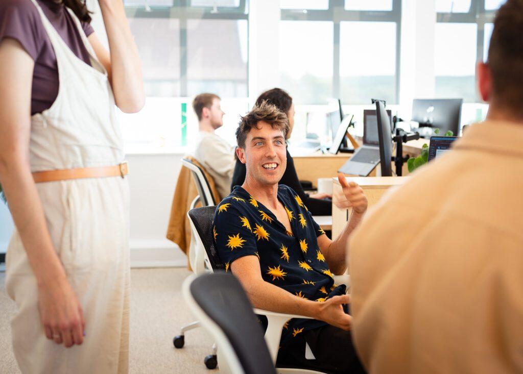 Web developers discussing website maintenance in the office around computers