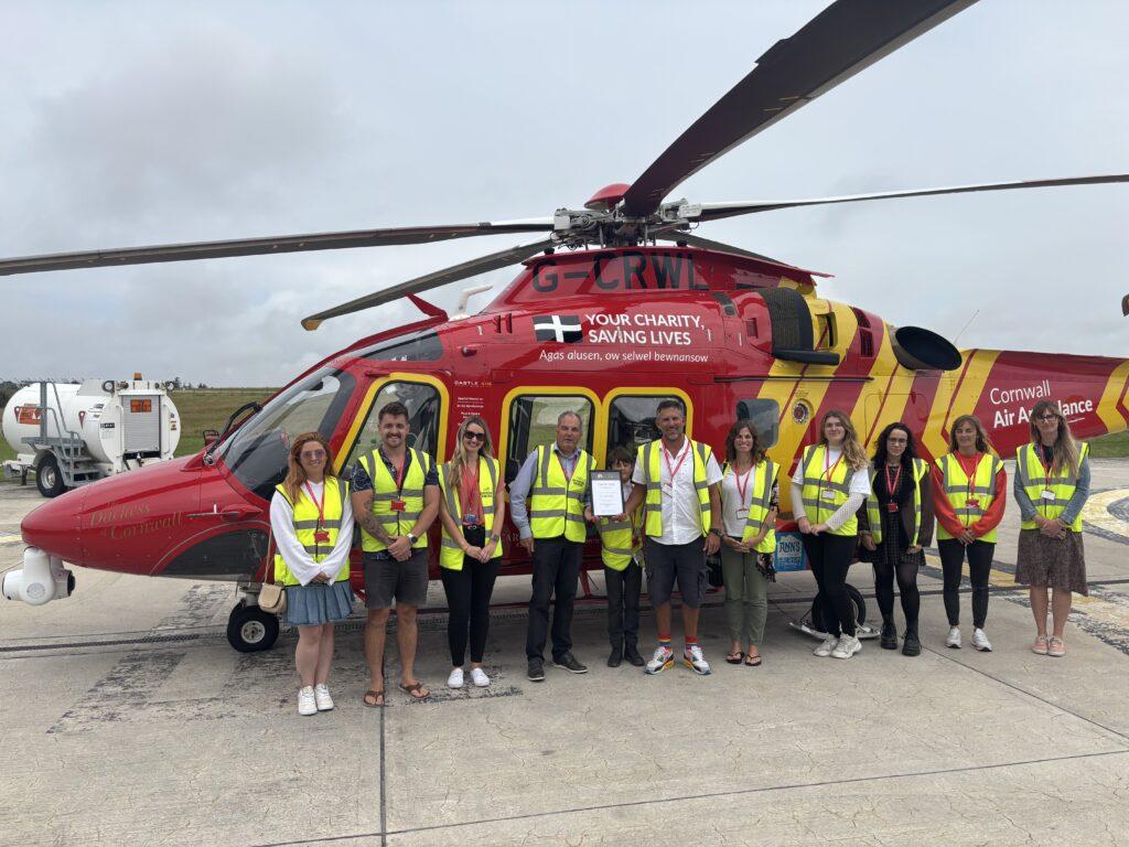 Repurposing Content for Maximum Impact and Value 6 Solve team stood infront of Cornwall Air Ambulance Helicopter after collecting content from the day