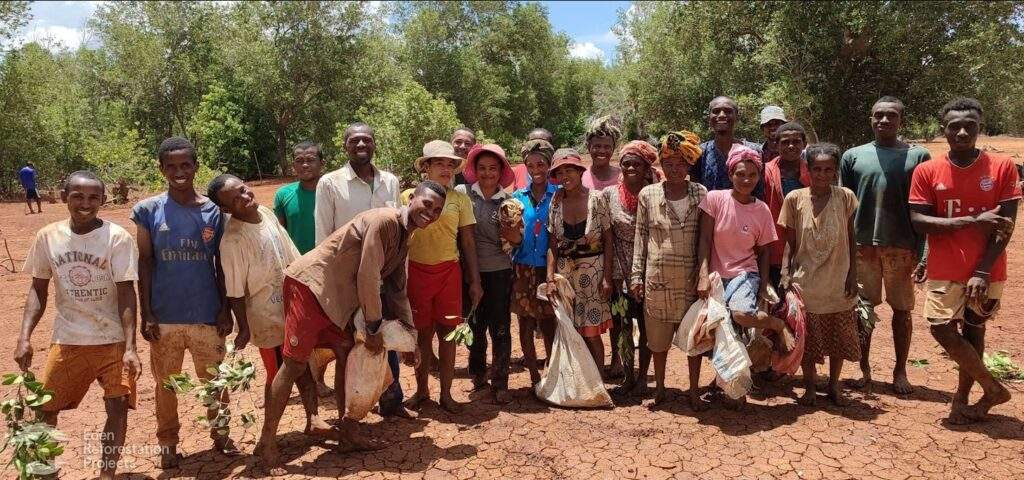 Group of people planting at Kandrany, Madagascar stood smiling at camera