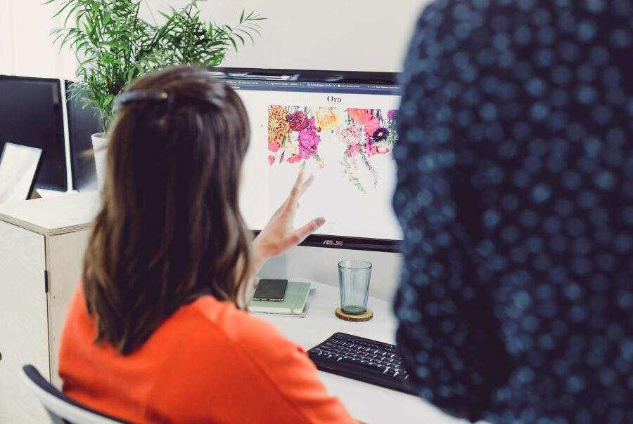 A female web designer reviewing colour contrast on a floral website design.