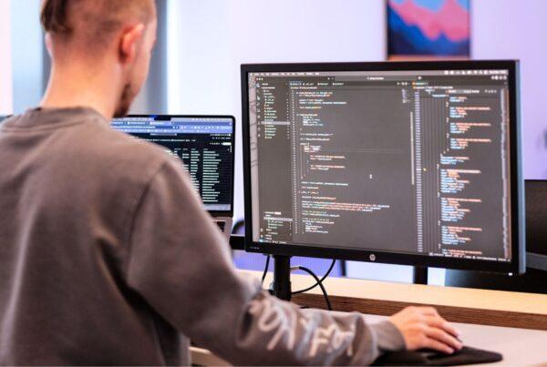 How Custom Website Development Drives Business Growth 4 A man stands at a stand up desk, coding for custom website development