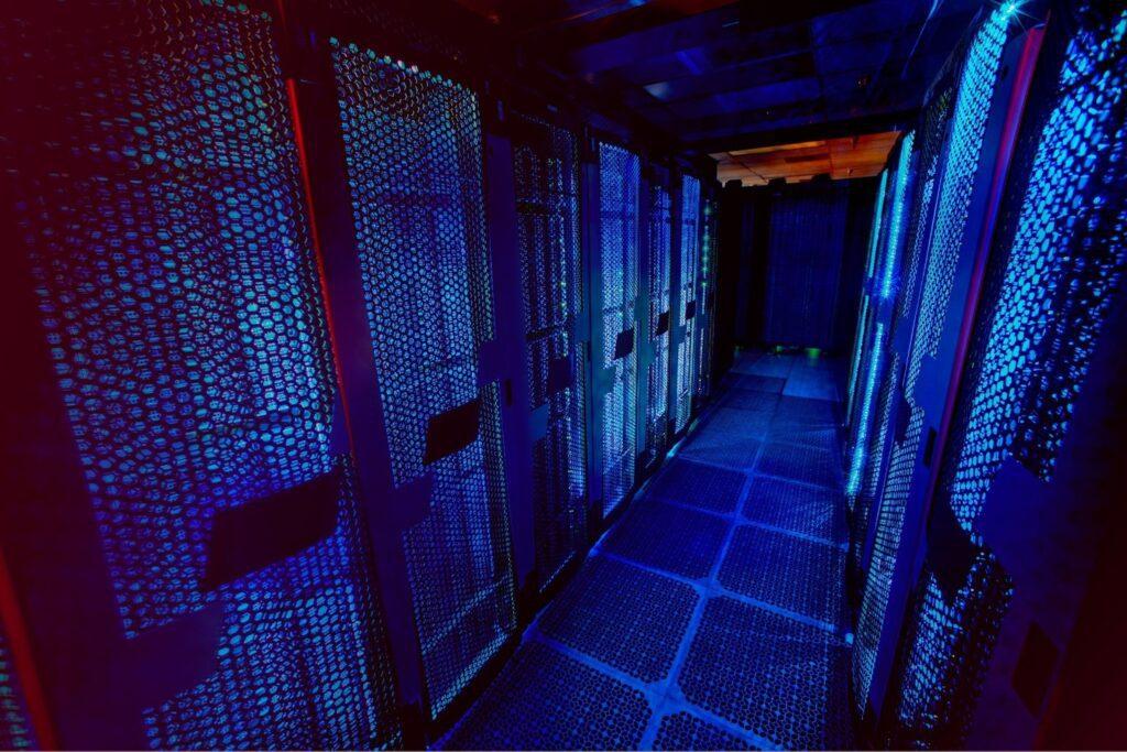 A blue and black data centre with going lights.