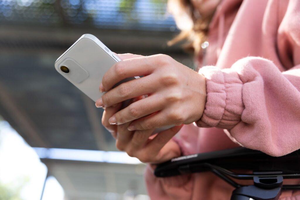 11 Common PPC Mistakes to Avoid in Your Next Campaign 4 a woman in a pink jumper holding a white phone in her hands