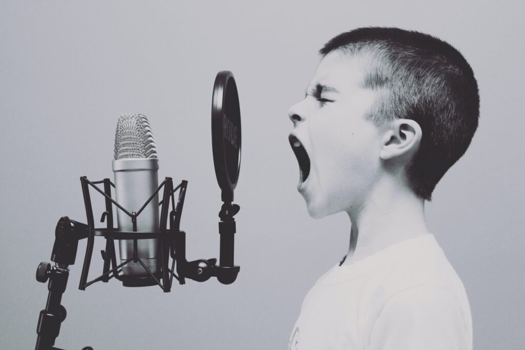 boy talking into a recording studio microphone