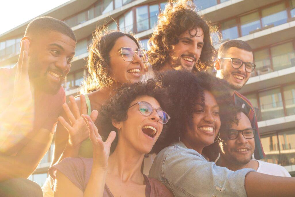A group of friends taking a selfie at golden hour, smiling.