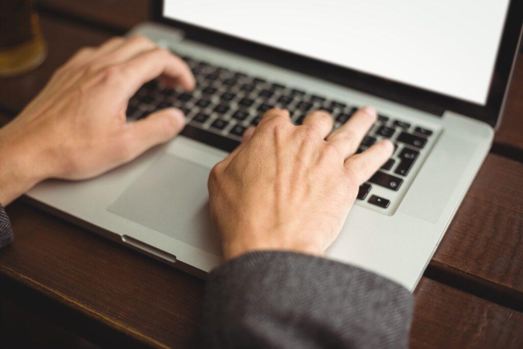 SEO Content Creation That Connects Users and Search Engines 4 Hands on a laptop typing. SEO content creation.
