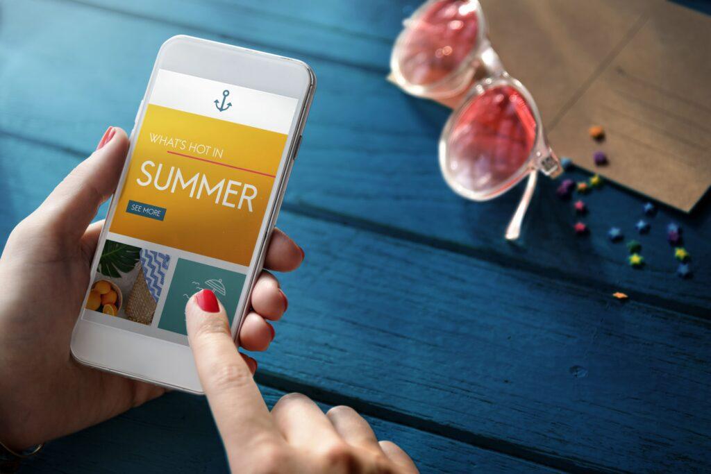 A phone with "What's on for Summer" on the screen.